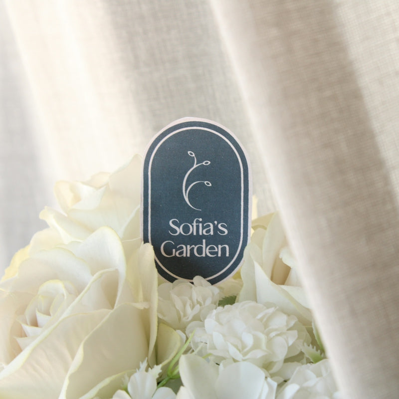 a bouquet of white flowers sitting next to a curtain