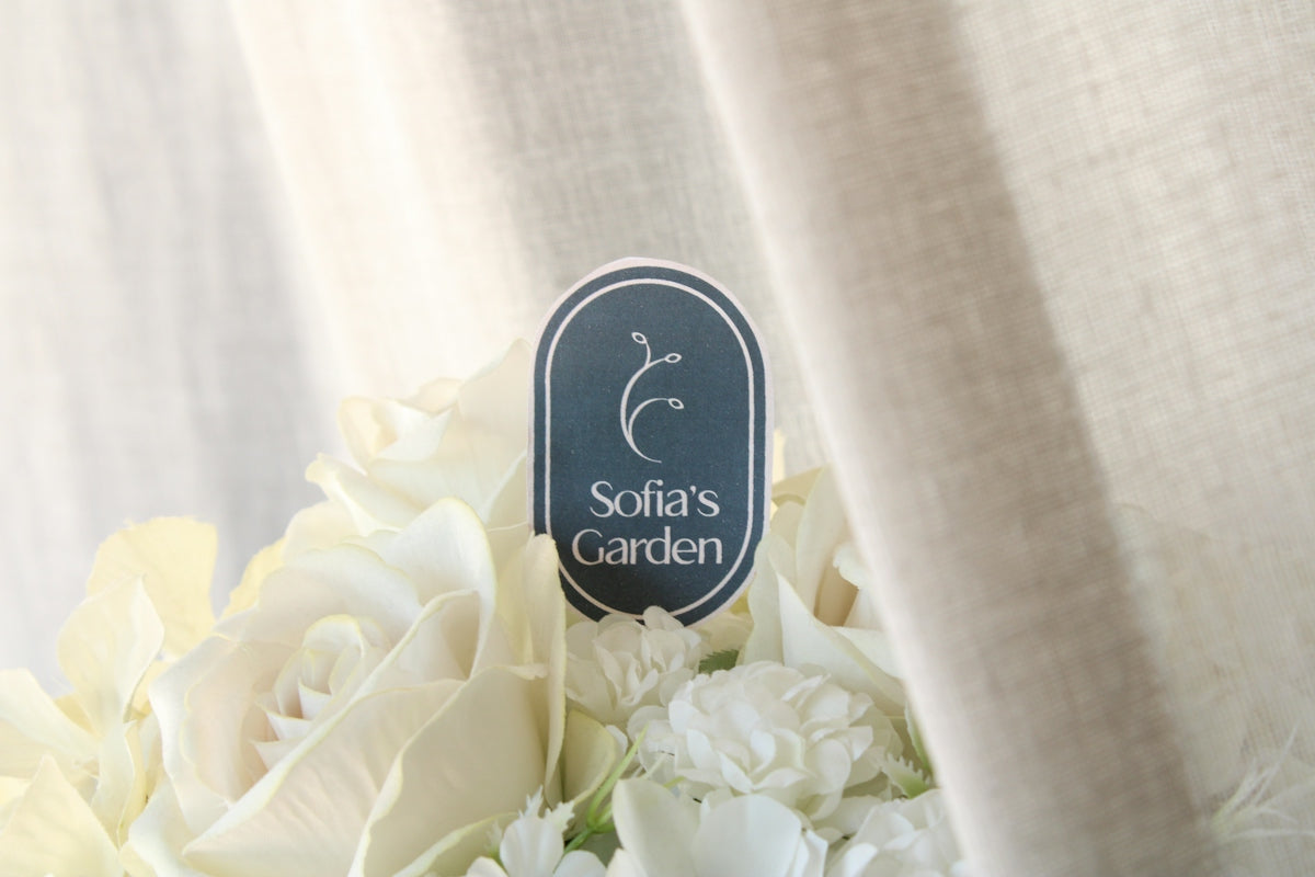 a bouquet of white flowers sitting next to a curtain